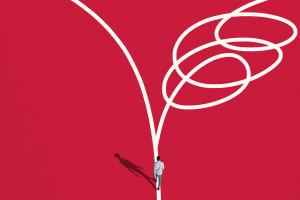 On red background, graphic of man at intersection of two paths: one is a curved line and the other is a squiggle