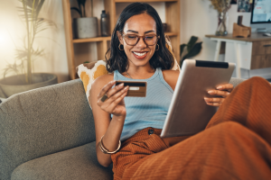 Woman reading credit card information while using a tablet