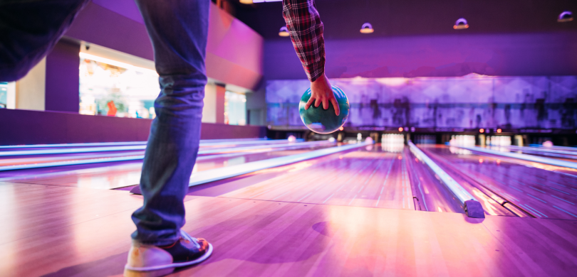 Man throwing bowling ball down lane